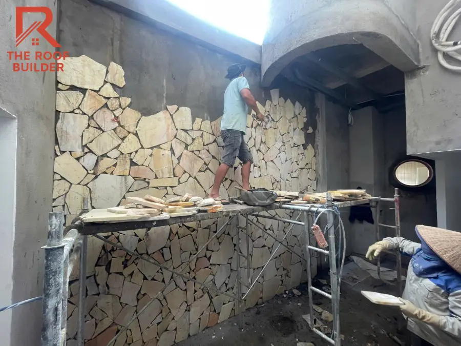 Thợ The Roof Builder đang thi công ốp đá tự nhiên trên mảng tường lớn tại công trình thực tế.
